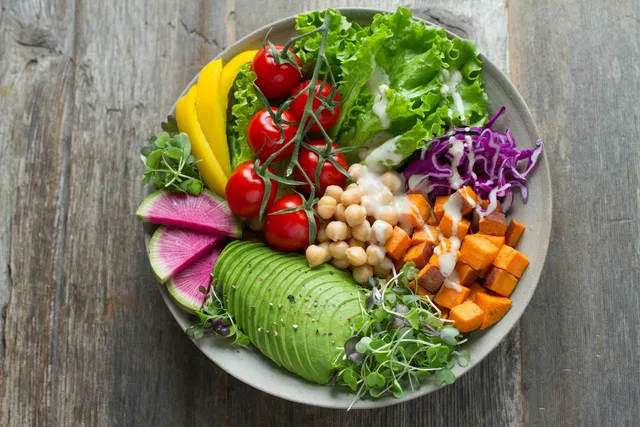 Colorful bowl of fresh vegetables, avocado, chickpeas, and greens